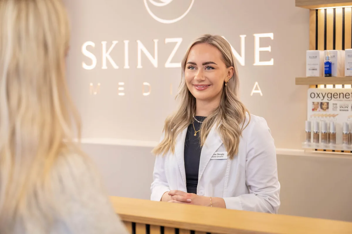 Behandler tar imot i resepsjonen hos SkinZone Medispa